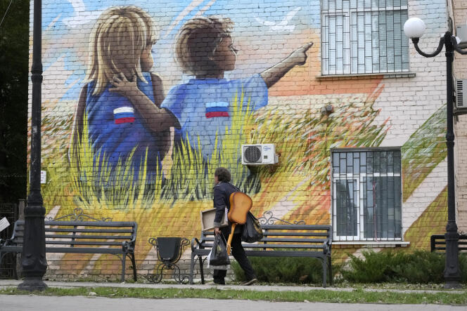 Une peinture murale représente des enfants portant des vêtements ornés de drapeaux russes, à Louhansk, en territoire prorusse, le 27 septembre 2022.