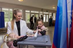 Une femme vote avec ses enfants à Louhansk, territoire prorusse situé en Ukraine, le 27 septembre 2022. 
