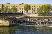 Photo : un bateau-mouche plein de touristes passant sous le Pont des Arts,  Paris.  