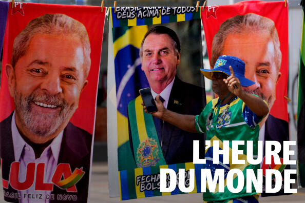A demonstrator dressed in the colors of the Brazilian flag performs in front of a street vendor’s towels for sale featuring Brazilian presidential candidates, current President Jair Bolsonaro, center, and former President Luiz Inacio Lula da Silva in Brasilia, Brazil, Tuesday, Sept. 27, 2022. Brazilians head to polls on Oct. 2 to elect a president, vice president, governors and senators. (AP Photo/Eraldo Peres)