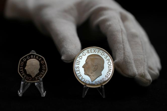 Présentation à la presse, le 29 septembre 2022, à Londres, des futures pièces britanniques : à gauche celle de 50 pence, et à droite celle commémorative de 5 livres, qui sera parmi les premières à afficher le portrait du nouveau roi, Charles III.