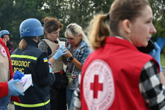 Des psychologues aident une personne qui se trouvait dans un convoi de véhicules civils, qui a été touché par un tir de missile, à Zaporijia, le 30 septembre 2022.