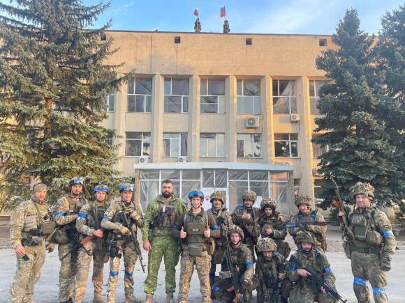 Des troupes ukrainiennes posent devant un immeuble administratif à Lyman, le 1er octobre 2022.