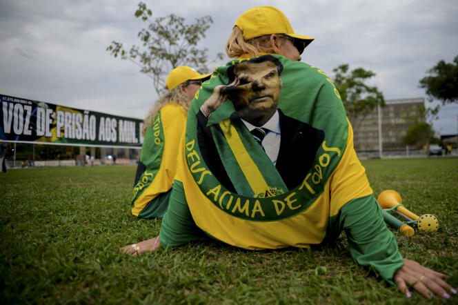 Partidarios del actual presidente Jair Bolsonaro, portando toallas con su imagen, esperan los resultados tras el cierre de las urnas, en Brasilia, el 2 de octubre de 2022. 
