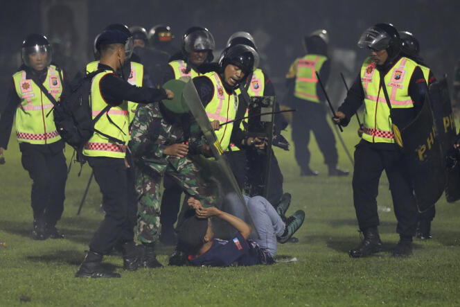 Security officers detain a fan during a clash between supporters of two Indonesian soccer teams at Kanjuruhan Stadium in Malang, East Java, Indonesia, October 1, 2022.