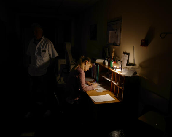 Une soignante remplit des documents à son bureau, installé dans un couloir, le 25 septembre 2022.
