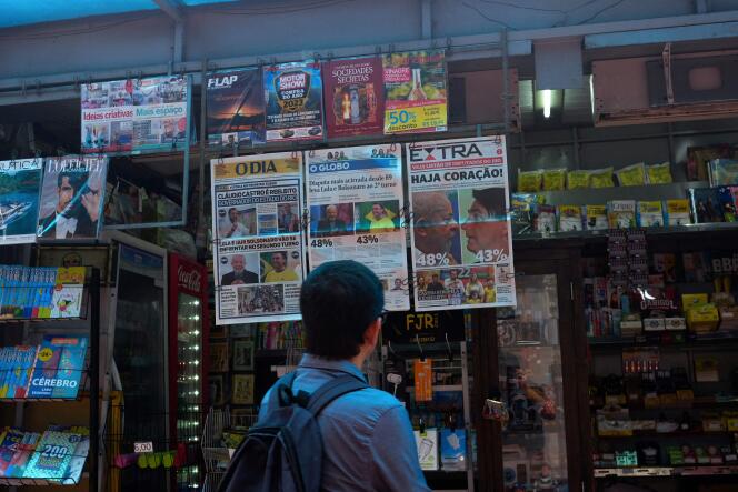 A man looks at the front page of Brazilian newspapers displaying the results of the first round of the presidential election, in Rio de Janeiro, Brazil, October 3, 2022. 