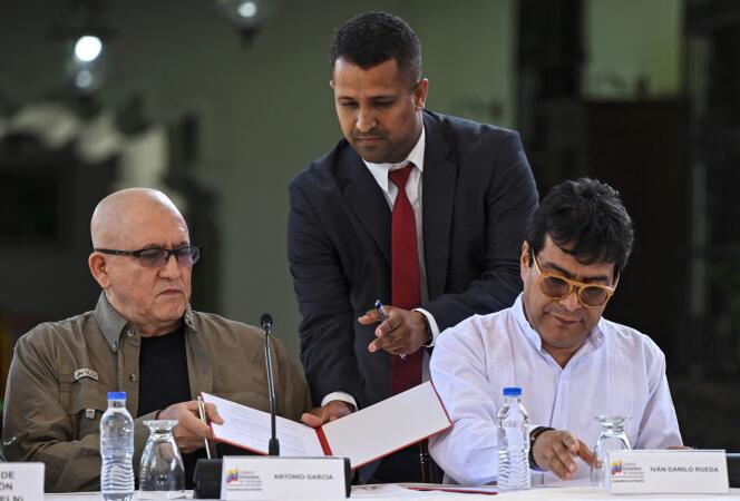 Le premier commandant de l’Armée de libération nationale colombienne (ELN), Antonio Garcia (à gauche), et le commissaire à la paix du gouvernement colombien, Danilo Rueda, signent des documents après avoir annoncé de nouveaux pourparlers de paix, à Caracas, le 4 octobre 2022. 