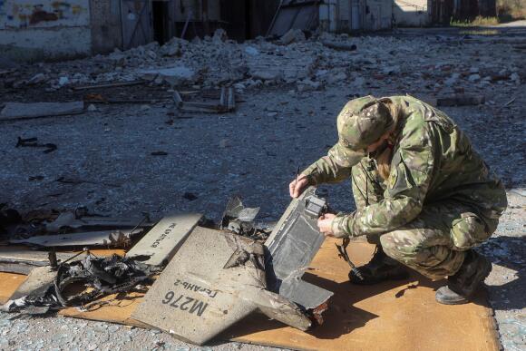 A Ukrainian policewoman examines the remains of a drone suspected to be a Shahed-136, renamed Geran-2 by the Russians, in Kharkiv on October 6, 2022.
