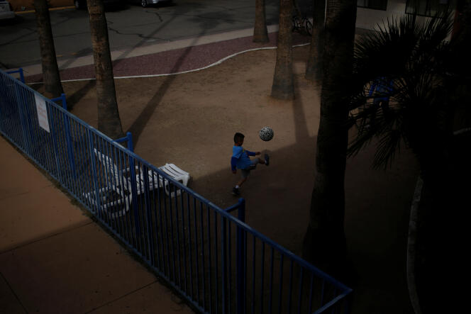 Un joven migrante juega con una pelota de fútbol en su motel en Tucson, Arizona, en 2018. 