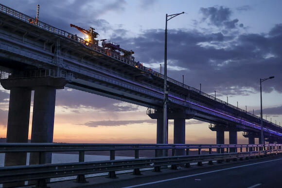 Des ouvriers réparent la partie ferroviaire du pont de Crimée, dans la soirée de samedi 8 octobre 2022.