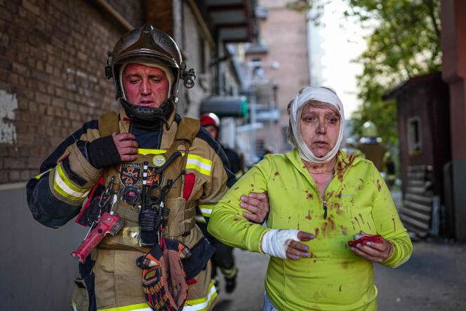 Esta foto publicada por el Servicio de Emergencia de Ucrania el 10 de octubre de 2022 muestra a un rescatista ayudando a una mujer herida después de múltiples bombardeos en la capital de Ucrania, Kyiv.