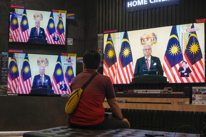 Un cliente en una tienda ve un discurso del primer ministro de Malasia, Ismail Sabri Yaakob, en la televisión el 10 de octubre de 2022, en Kuala Lumpur.