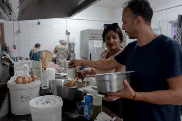 Aïssatou, qui réside à l’auberge, aide Salem, cuisinier du lieu depuis mars 2022. A Marseille, le 27 septembre 2022.