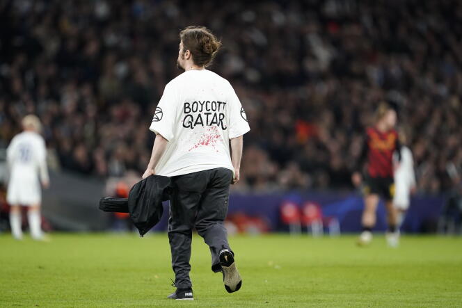 Un militant porte un t-shirt appelant à boycotter la Coupe du monde au Qatar, sur la pelouse du stade de FC Copenhague lors du match de Ligue des champions contre Manchester City, le 11 octobre 2022.