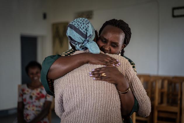 Emilienne Mukansoro réconforte une femme lors d’une thérapie de groupe dans sa maison à Mushubati, le 16 août 2022.