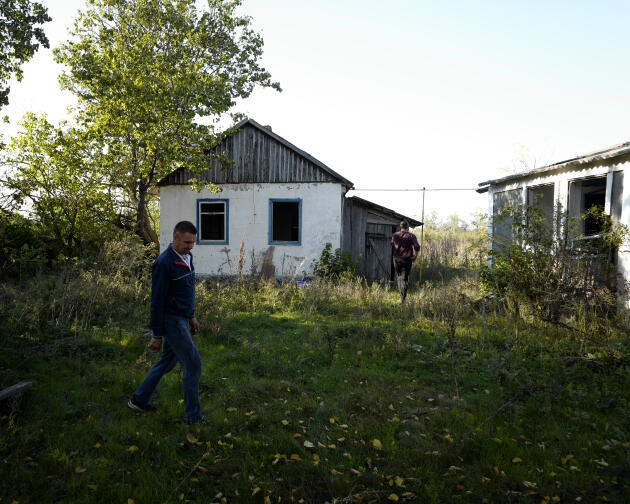 Dos residentes inspeccionan los alrededores de una casa que sirvió como base para los soldados rusos en el pueblo de Mirolyubivka en el norte de la región de Kherson en Ucrania el 8 de octubre de 2022.