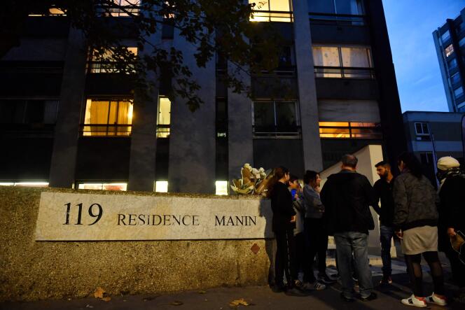 Residentes al pie del edificio donde vivía el adolescente encontrado muerto en un baúl, en el distrito 19 de París, el 15 de octubre de 2022.