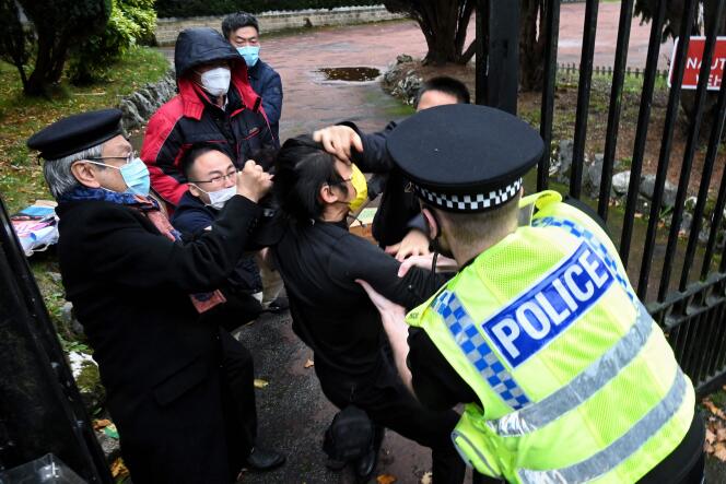 This handout from The Chaser News taken on October 16, 2022 and released to AFP on October 17 shows an incident involving a scuffle between a Hong Kong pro-democracy protester (C) and Chinese consulate staff, as a British police officer attempts to intervene.