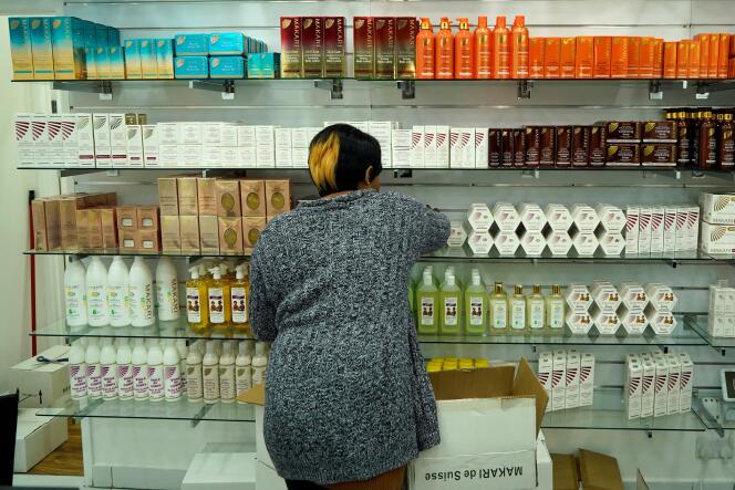 A worker arranges hair products on the shelves of a hair salon in southwest London on December 1, 2020.