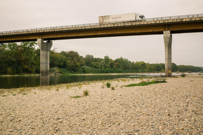 Une plage de circonstance est apparue le long de la Garonne sous le pont de Beauregard, près d'Agen (Lot-et-Garonne), le 19 octobre 2022. Les traces sur les piles du pont montrent le niveau habituel du fleuve à cette période del año.