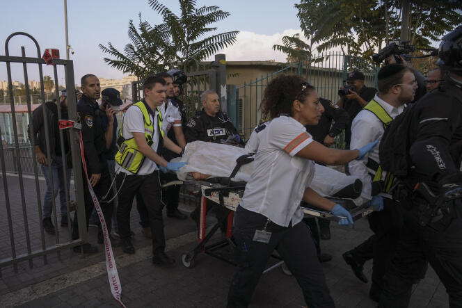 Médicos y policías israelíes cargan al sospechoso de un apuñalamiento contra un israelí, después de que la policía israelí le disparara, en Jerusalén el 22 de octubre de 2022.
