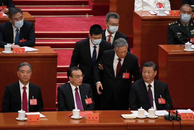 El expresidente Hu Jintao es presionado para abandonar la ceremonia de clausura del XX Congreso del Partido Comunista de China, mientras Xi Jinping (derecha) permanece impasible, en Beijing, el 22 de octubre de 2022. 