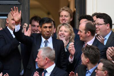 TOPSHOT - New Conservative Party leader and incoming prime minister Rishi Sunak (C) waves as he arrives at Conservative Party Headquarters in central London having been announced as the winner of the Conservative Party leadership contest, on October 24, 2022. Britain's next prime minister, former finance chief Rishi Sunak, inherits a UK economy that was headed for recession even before the recent turmoil triggered by Liz Truss. (Photo by Daniel LEAL / AFP)
