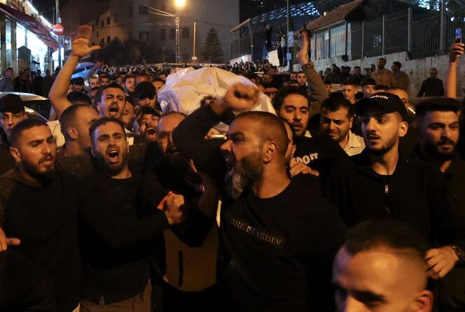 A man's body is carried by a crowd after clashes with Israeli forces in Nablus, West Bank, on October 25, 2022.
