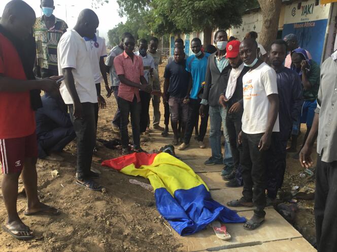 Des manifestants sont rassemblés autour d’un corps recouvert du drapeau tchadien, à N’Djamena, le 20 octobre 2022.