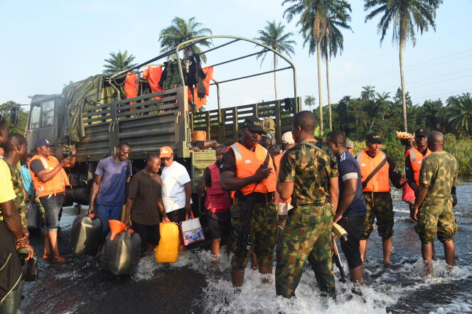 Des personnes arrivent à bord d’un camion fourni par la marine nigériane pour évacuer les personnes déplacées par les inondations, dans le district d’Ahoada de l’Etat de Rivers, le 22 octobre 2022.