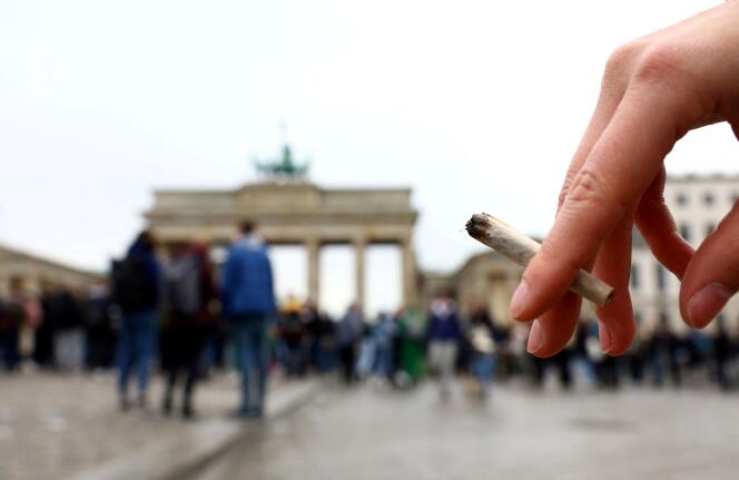 Frente a la Puerta de Brandenburgo en Berlín, una persona sostiene un porro en el Día Internacional del Cannabis el 20 de abril de 2022. 