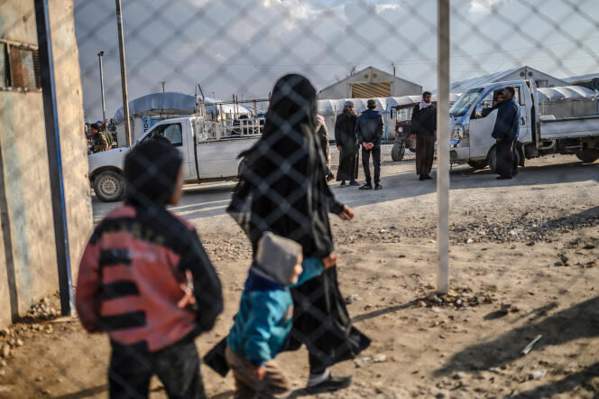 A French woman, suspected of having belonged to the Islamic State organization, walks with her child, in the Al-Hol detention camp, in Syria, in 2019. 