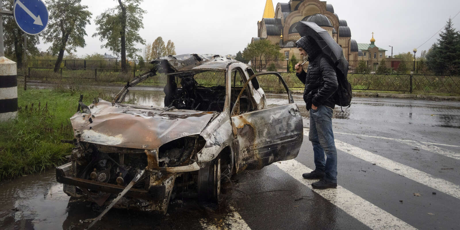 Un passant regarde une voiture endommagée par des bombardements russes à Bakhmout, dans la région de Donetsk, dans l’est de l’Ukraine, mercredi 26 octobre 2022.