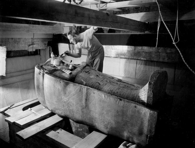 L’archéologue britannique Howard Carter penché sur le couvercle du second cercueil dans la tombe de Toutankhamon, en octobre 1925. Il avait découvert l’entrée du tombeau trois ans plus tôt.