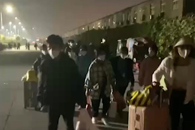Des salariés quittent un complexe Foxconn à Zhengzhou, dans la province du Henan, en Chine, le 29 octobre 2022, après que des travailleurs contaminés par le Covid-19 ont été mis en quarantaine dans l’usine.  La photo a été prise à partir d’une séquence vidéo et publiée par Hangpai Xingyang.