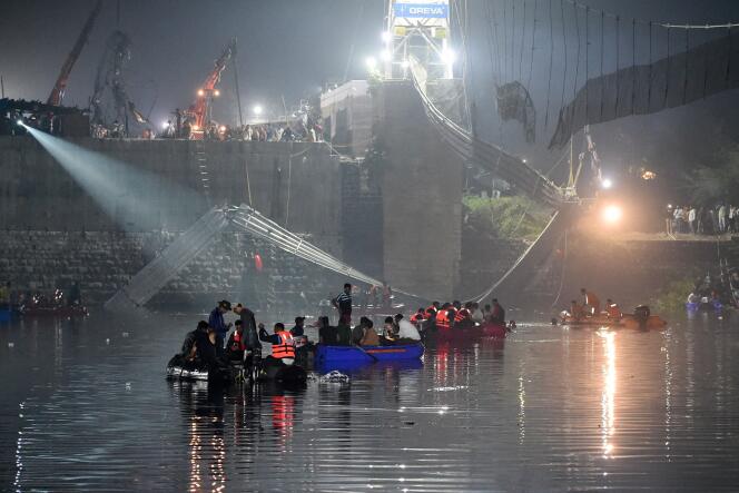 Des secouristes indiens mènent des opérations de recherche après l’effondrement d’un pont sur la rivière Machchhu à Morbi, en Inde, le 31 octobre 2022.