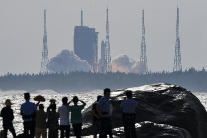 La gente osserva il lancio del razzo Long March 5B Y4 che trasporta il modulo Mengtian, dal Wenchang Launch Center, dall'isola tropicale di Hainan, in Cina, il 31 ottobre 2022. Foto via Xinhua.