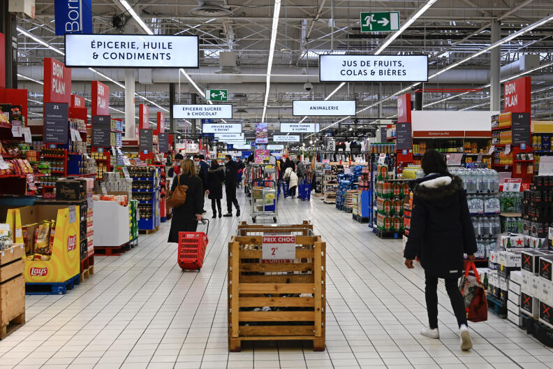 Consumers shop at Carrefour supermarket in Langueux, western France, on January 29, 2022. (Photo by DAMIEN MEYER / AFP)