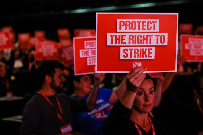 Des membres du public tiennent des pancartes sur lesquelles on peut lire « Protéger le droit de grève », lors de la troisième journée du Trades Union Congress (TUC), le 20 octobre 2022, à Brighton, au Royaume-Uni. 