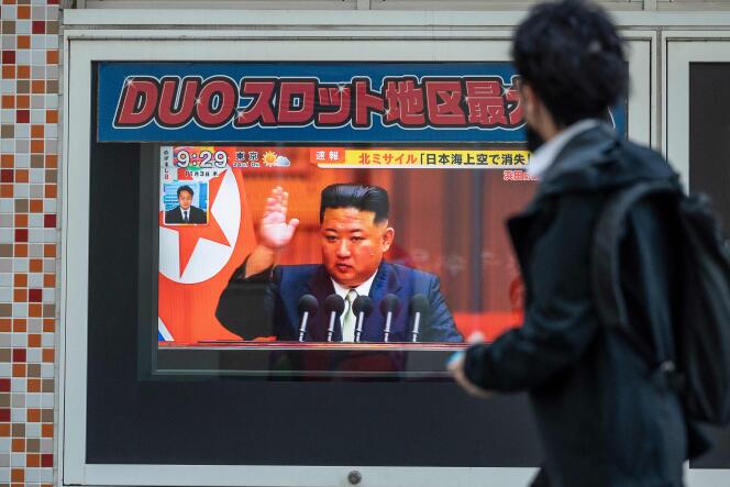 Un transeúnte en una calle de Tokio observa el discurso del líder norcoreano Kim Jong-un sobre los nuevos lanzamientos de misiles.
