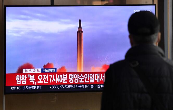A man watches a television screen showing a news broadcast with file footage of a North Korean missile test, at a railway station in Seoul on November 3, 2022.
