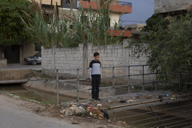 Omar Abbas, 11, is the nephew of Siham Abbas, a widow who sells sweets from her house. The canal is used for irrigation and domestic use, in the village of Haryk, near Bebnine, northern Lebanon, on Tuesday, November 1, 2022.