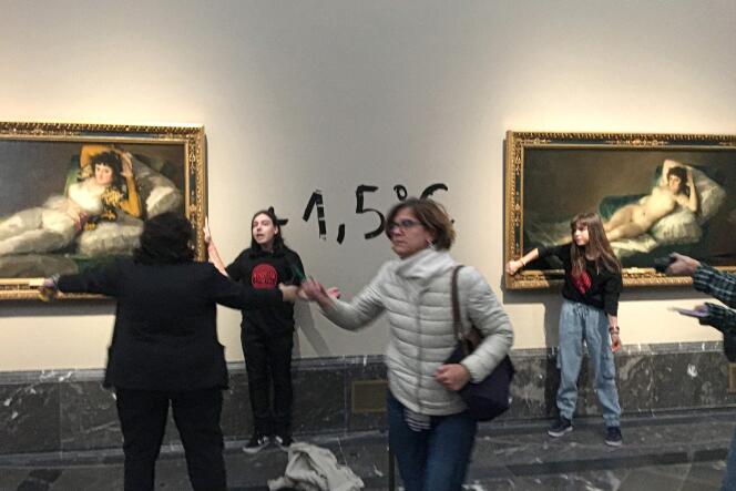 Deux militantes écologistes se collant la main sur « La Maja nue » et « La Maja vêtue », du peintre espagnol Francisco de Goya, au musée du Prado, à Madrid, samedi 5 novembre 2022.