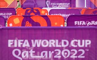 A worker walks past FIFA World Cup banners outside the Khalifa Stadium in Doha on November 6, 2022, ahead of the Qatar 2022 FIFA World Cup football tournament. (Photo by Kirill KUDRYAVTSEV / AFP)