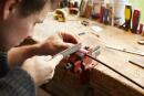 Craftsman repairing bow in violin workshop
