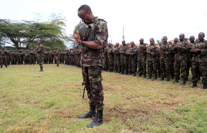 Los soldados kenianos presentan sus respetos durante la presentación de la bandera en el campamento de Embakasi en Nairobi, donde se reúnen los soldados antes de su despliegue en la República Democrática del Congo.