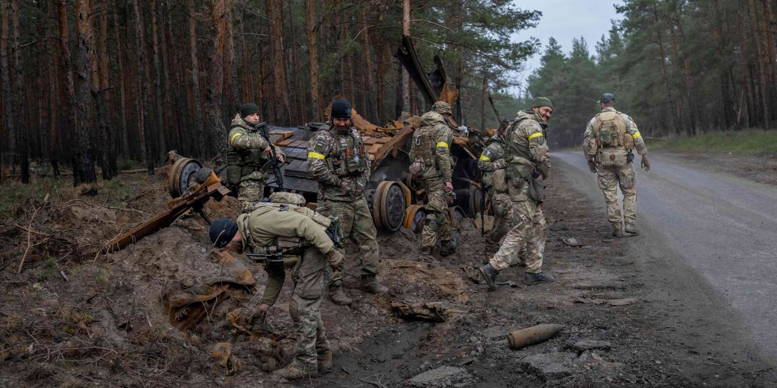 Des soldats et des combattants volontaires ukrainiens devant un char russe détruit dans un lieu non divulgué, dans l’est de l’Ukraine, le 10 novembre 2022.