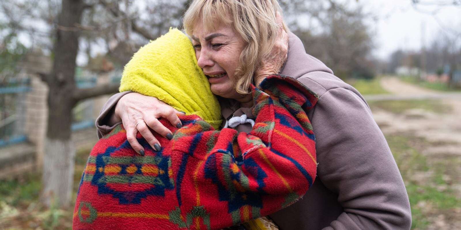 Svitlana Striletska, 50 ans, directrice d’école (à droite), prend dans ses bras Galina Timofievna (à gauche), 84 ans, dans le village libéré de Pravdyne, dans la région de Kherson, le 12 novembre 2022, après avoir enduré huit mois d’occupation russe.