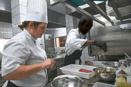 French cheffe Sandrine Sollier and prisoner cook Jeffrey Sandiford work in the kitchen of the "Les beaux mets" restaurant inside the Baumettes prison in Marseille, on November 2, 2022. - "Les beaux mets" restaurant, where detainees of the Baumettes prison cook meals, will open to the public on November 15, 2022. (Photo by Christophe SIMON / AFP)